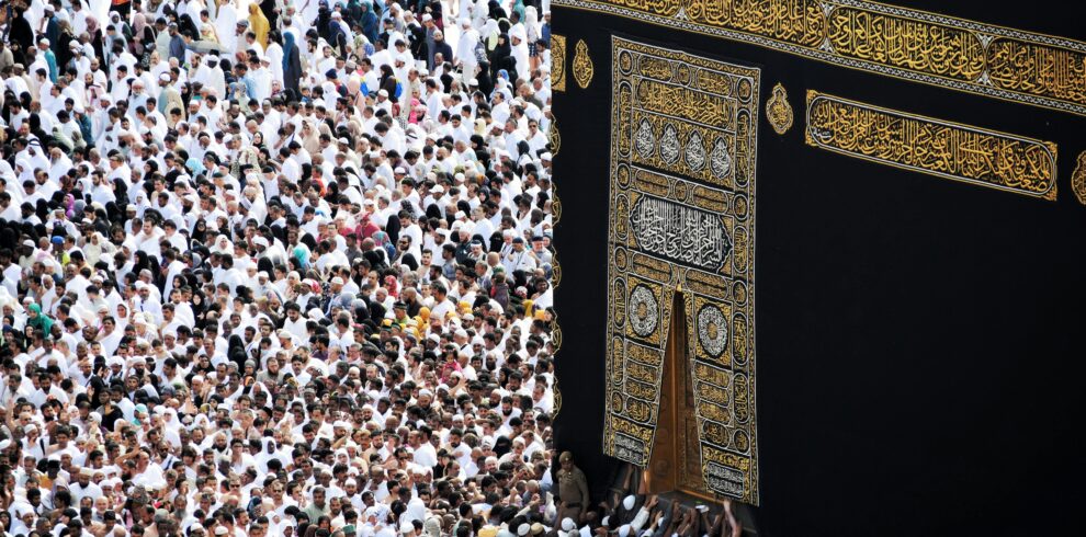 Mass of pilgrims in traditional attire at Kaaba during the Hajj pilgrimage.